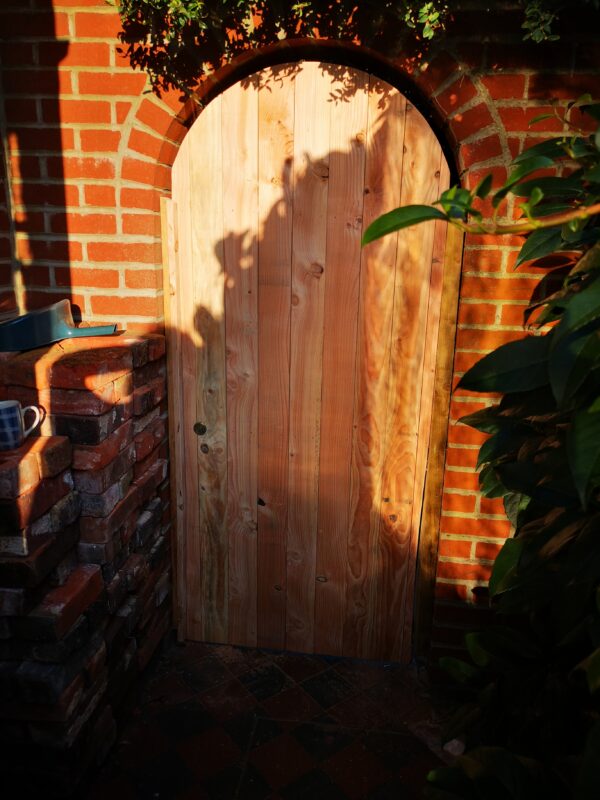 arched wooden gate in a brick wall