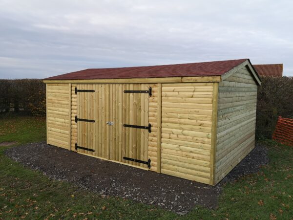 large wooden shed with double doors that are closed and apex roof
